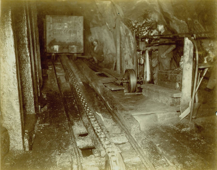 Car lift attended by two miners.